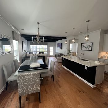 Modern open-concept kitchen and dining area with black and white color scheme and hardwood floors