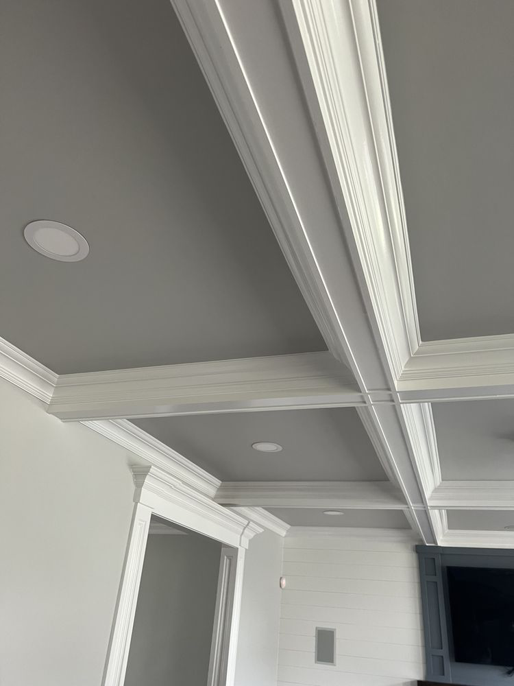 Modern ceiling with white crown molding, recessed lights, and coffered ceiling detail