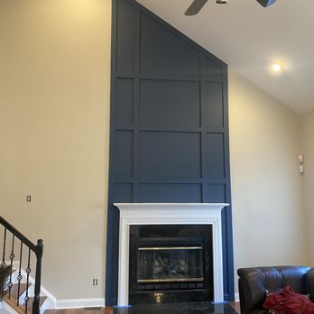 Modern fireplace with dark blue tile surround and white mantel in residential living room