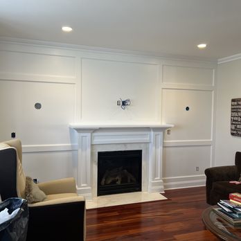 Modern living room with white fireplace, wood flooring, and recessed lighting